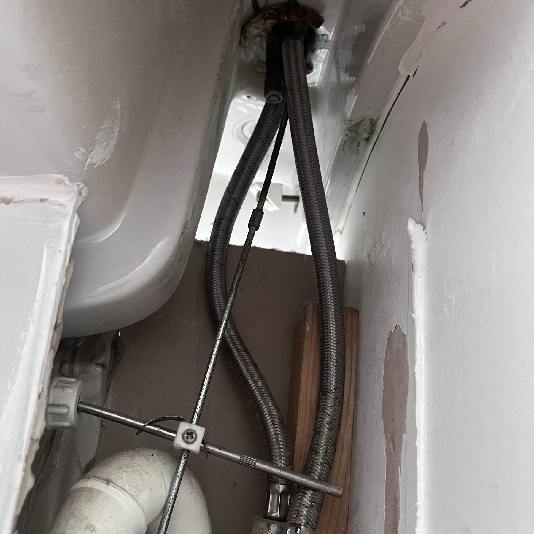 Pipework beneath a sink during a tap replacement